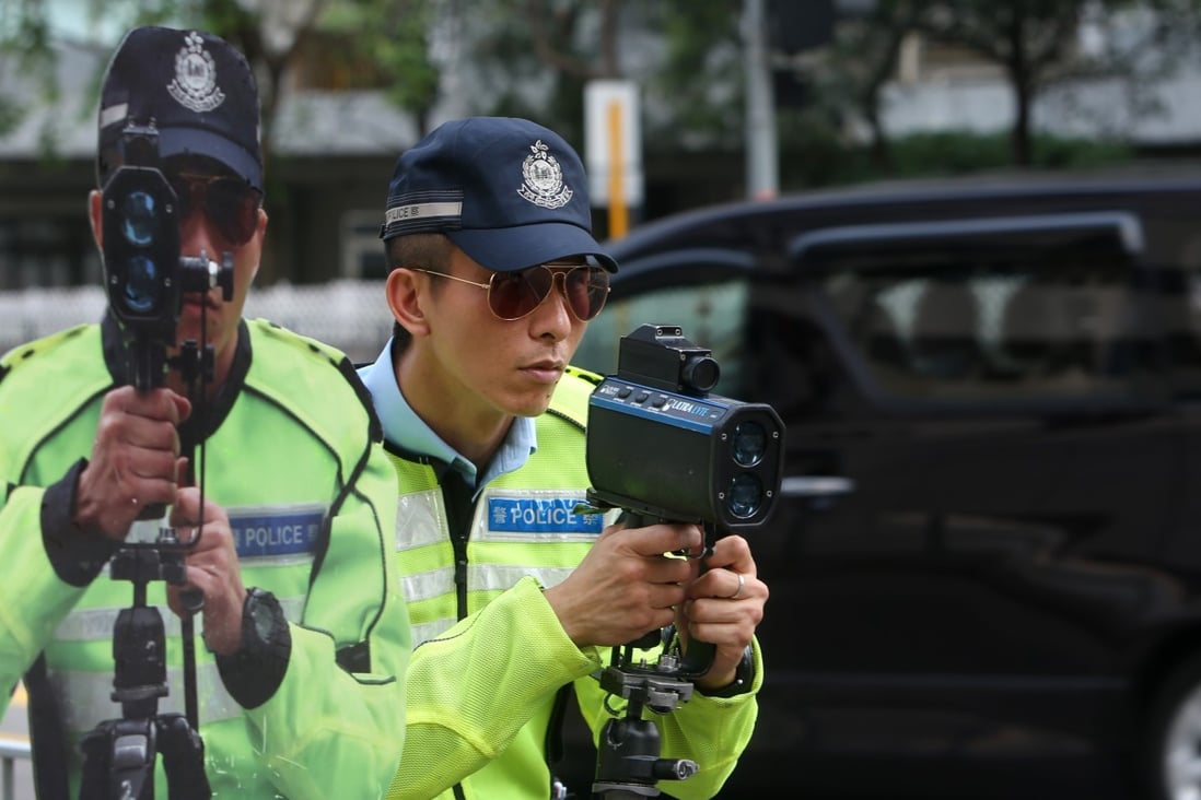 A Hong Kong police sergeant poses with a speed gun next to a cutout of an officer to be placed by the roadside as a reminder to drivers, in Tuen Mun in August 2012. Photo: Sam Tsang