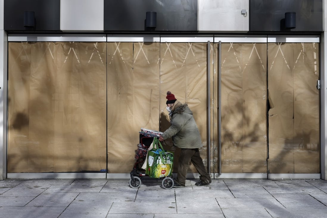 A homeless person walks in front of a closed store at a shopping street in Frankfurt, Germany, on Tuesday. Photo: EPA-EFE