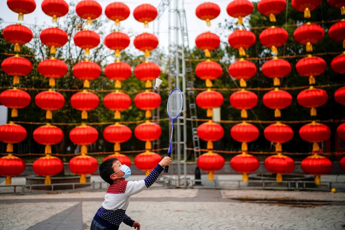 A boy in Wuhan plays badminton on a street decorated for Lunar New Year celebrations, a year after the city was the first epicentre of the coronavirus outbreak. Photo: Reuters