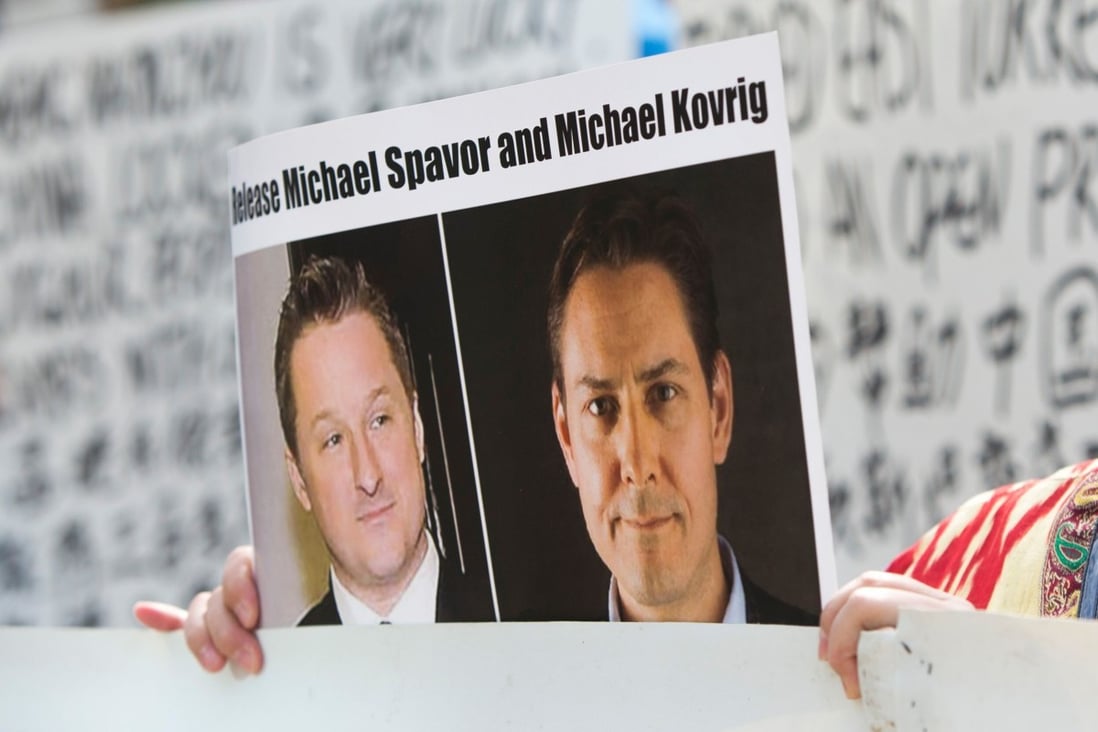 A supporter holds a picture of Michael Spavor (left) and Michael Kovrig, who have been detained in China for more than two years. Photo: AFP