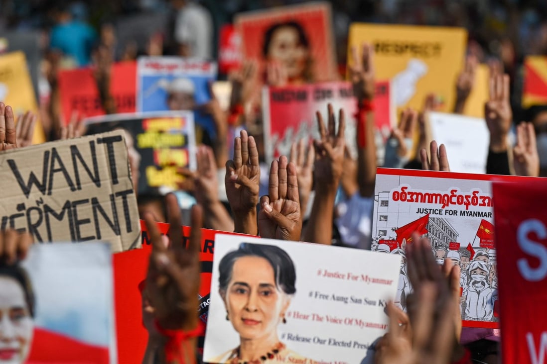 Protesters hold up the three finger salute with signs calling for the release of detained Myanmar civilian leader Aung San Suu Kyi in Yangon. Photo: AFP