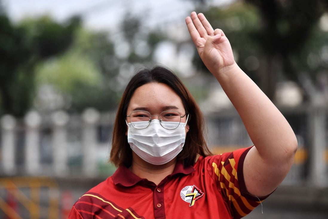 Pro-democracy protest leader Panusaya “Rung” Sithijirawattanakul holds up the three-finger salute outside the Office of the Attorney General in Bangkok on February 17. Photo: AFP