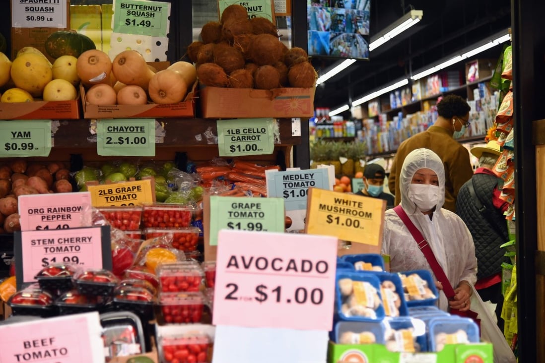 A person wearing protective gear walks past produce in a grocery store in New York on October 5, 2020. Photo: AFP