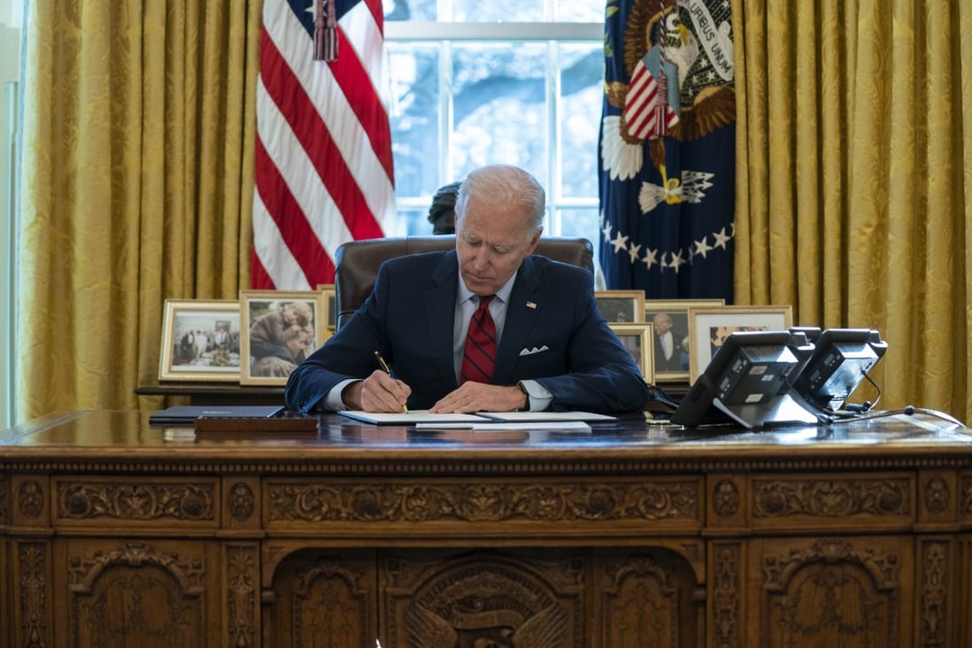 US President Joe Biden signs a series of executive orders in the Oval Office of the White House in Washington on January 28. Photo: AP