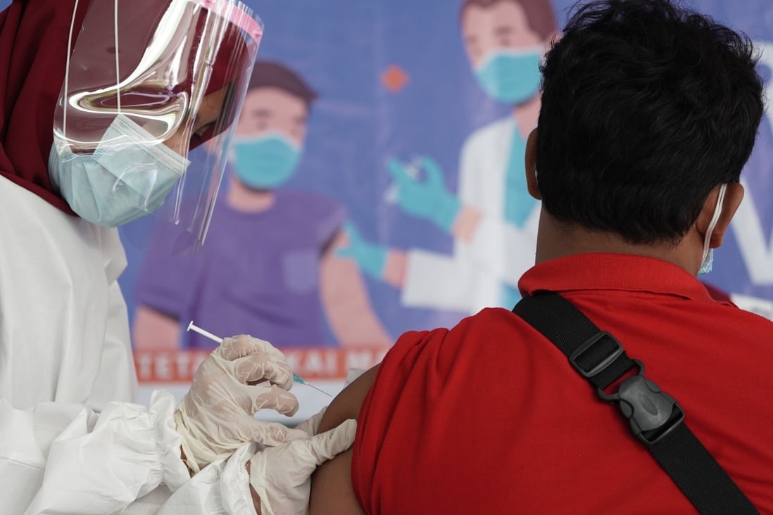A healthcare worker administers a dose of the Sinovac Biotech Covid-19 vaccine at Tanah Abang market in Jakarta, Indonesia. The country is aiming to inoculate more than 180 million people to reach herd immunity by the end of the year. Photo: Bloomberg
