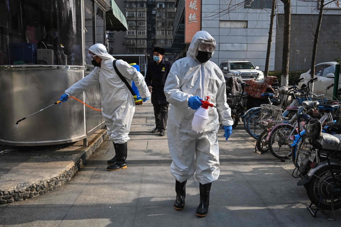People dressed in protective clothes disinfect an area in Wuhan, in China’s Hubei province, on January 29, 2020. A WHO team recently visited the city, where the first Covid-19 cases were detected, as part of a probe into the origins of Covid-19. Photo: AFP