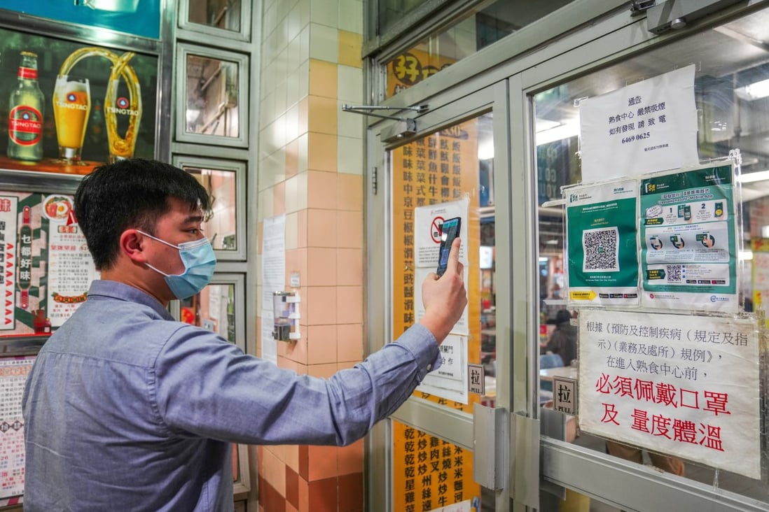 A diner scans the required QR code using Hong Kong’s Leave Home Safe app before entering a restaurant in Wan Chai on February 18. Photo: Sam Tsang