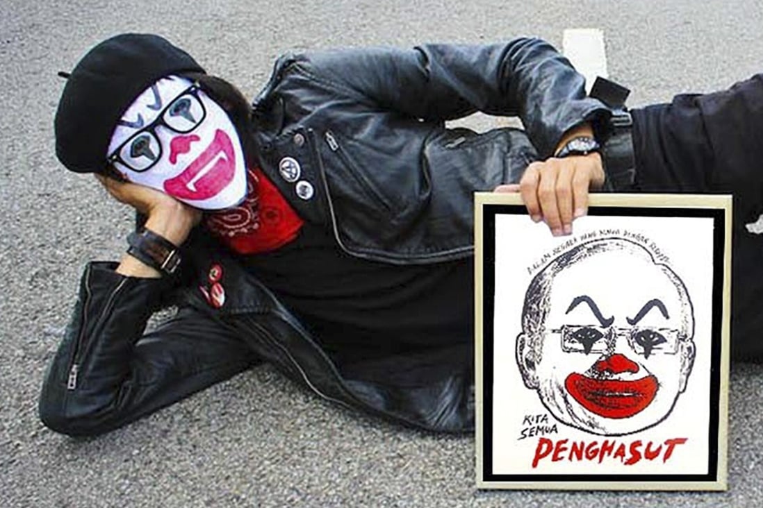 Malaysian artist Fahmi Reza posing with his work depicting former prime minister Najib Razak as a clown. Both Fahmi and Najib are users of Clubhouse. Photo: Facebook