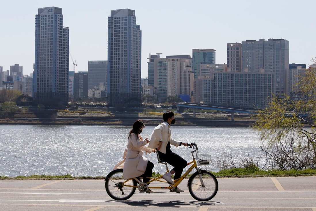 A couple wearing masks to protect against the coronavirus ride next to the Han River in Seoul, South Korea on April 4, 2020. The relative resilience and maturity of South Korea’s economy is the key factor underpinning confidence in the commercial property sector. Photo: Reuters