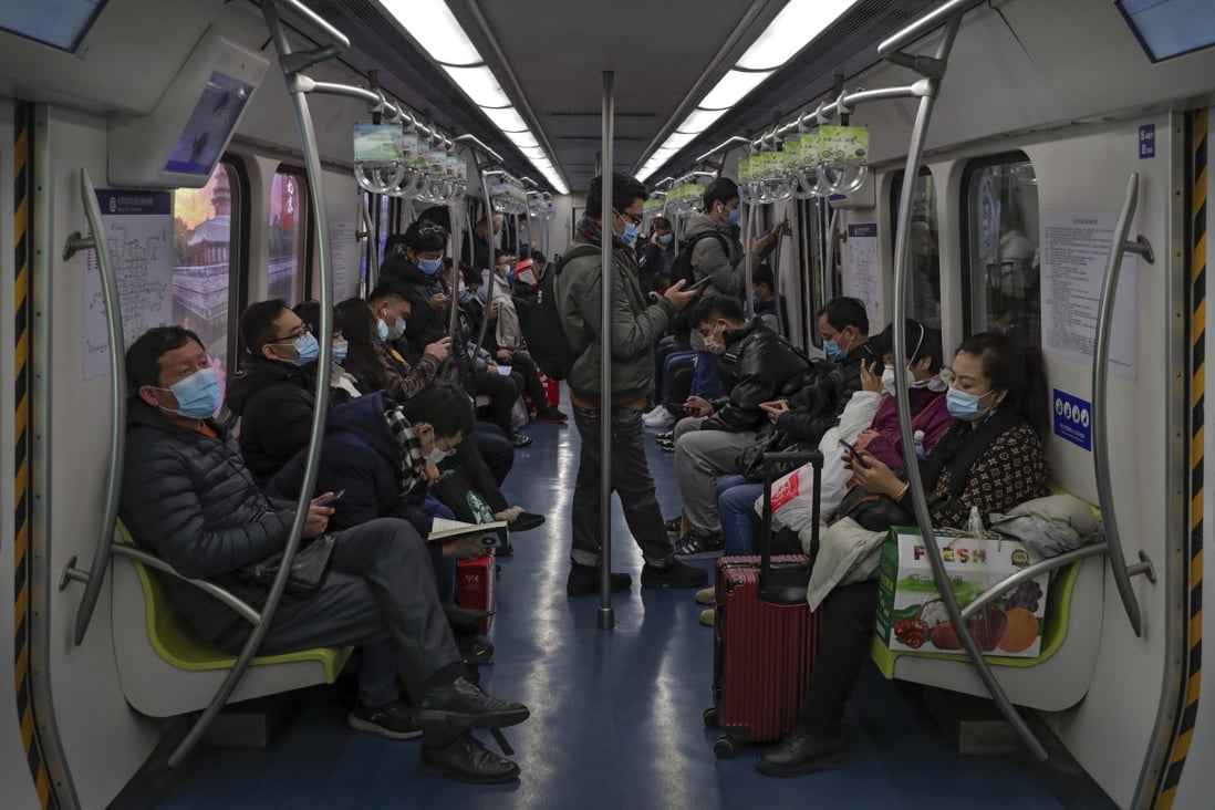 Commuters wearing face masks to help curb the spread of the coronavirus ride on a subway train in Beijing in February 2021. The Global Prediction System predicts new Covid-19 cases will hit a seasonal low in April at about 9.2 million worldwide but then climb to about 14 million cases in July. Photo: AP Photo