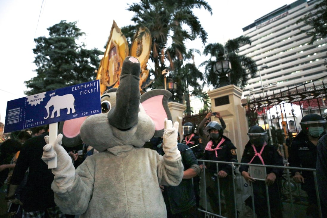 An anti-government protester wearing an elephant costume flashes the pro-democracy movement’s three-finger salute next to a line of anti-riot police officers at the Royal Thai Police Headquarters in Bangkok on Tuesday Photo: EPA-EFE