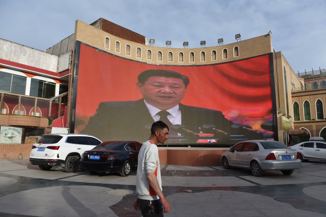 A man walks past a screen showing images of China’s President Xi Jinping in Kashgar, in China’s Xinjiang Uygur autonomous region. Photo: AFP