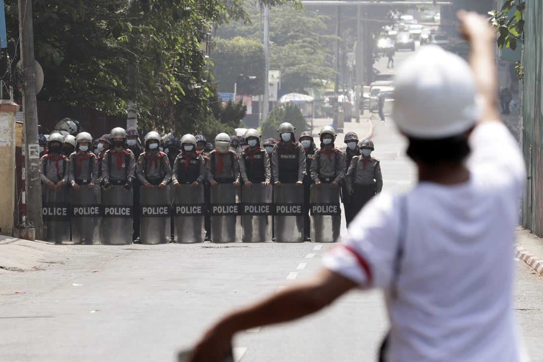 A demonstrator reacts on Friday as police officers block a road during a protest in Yangon against Myanmar’s military coup. Photo: EPA