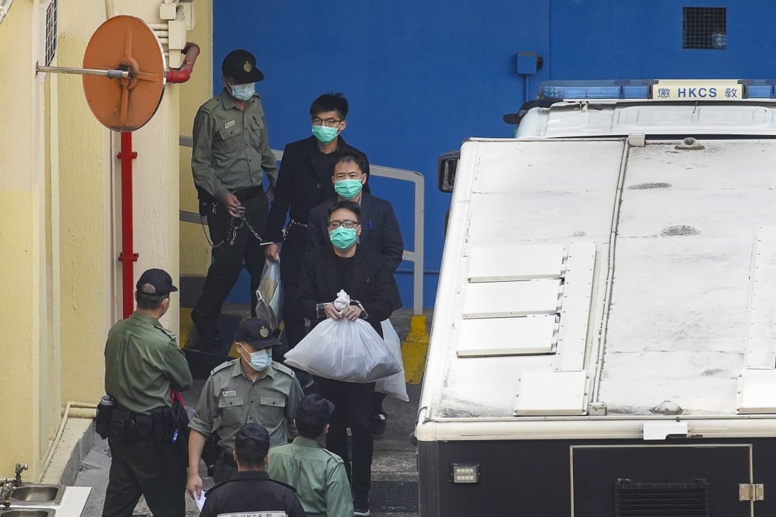 Opposition activists Joshua Wong, Wu Chi-wai and Tam Tak-chi (from back to front) are escorted from Lai Chi Kok Reception Centre on Tuesday morning. Photo: Winson Wong
