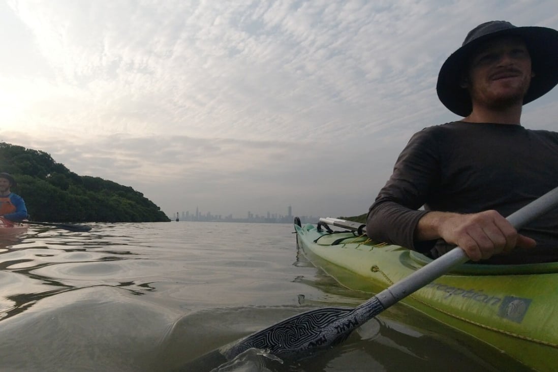Rory Mackay kayaks through Mai Po nature reserve with Shenzhen in the background. Photos: Handout