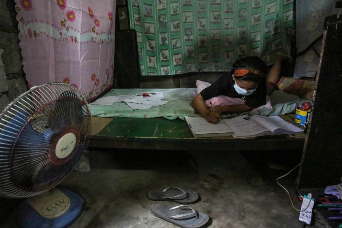 Filipino student Maria Fe Morallos does her schoolwork inside her home in an informal settlers area in Malabon City, suburban Manila. Photo: AFP