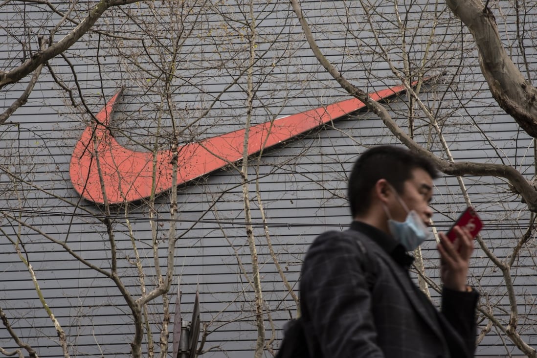 A pedestrian outside a Nike store in Shanghai on Friday. Photo: Bloomberg