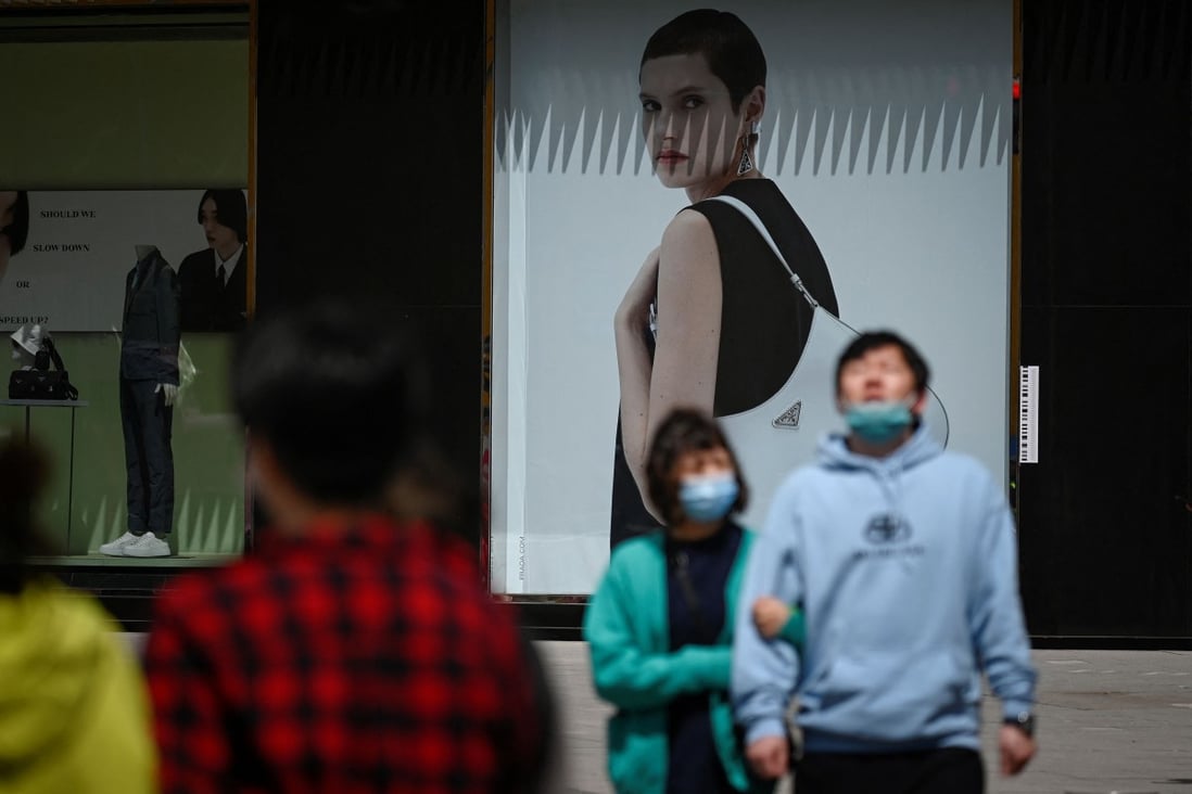 People walk past an advertising poster in Beijing on April 16. China’s core inflation, excluding food and energy prices, remains low, suggesting there is little visible inflation risk in the Chinese economy. Photo: AFP