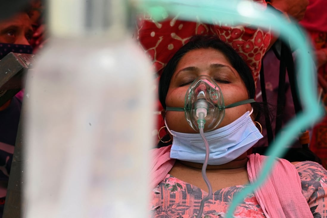 A patient breathes with the help of oxygen provided by a Gurdwara, a place of worship for Sikhs, under a tent installed along the roadside during India’s Covid-19 surge. Photo: AFP