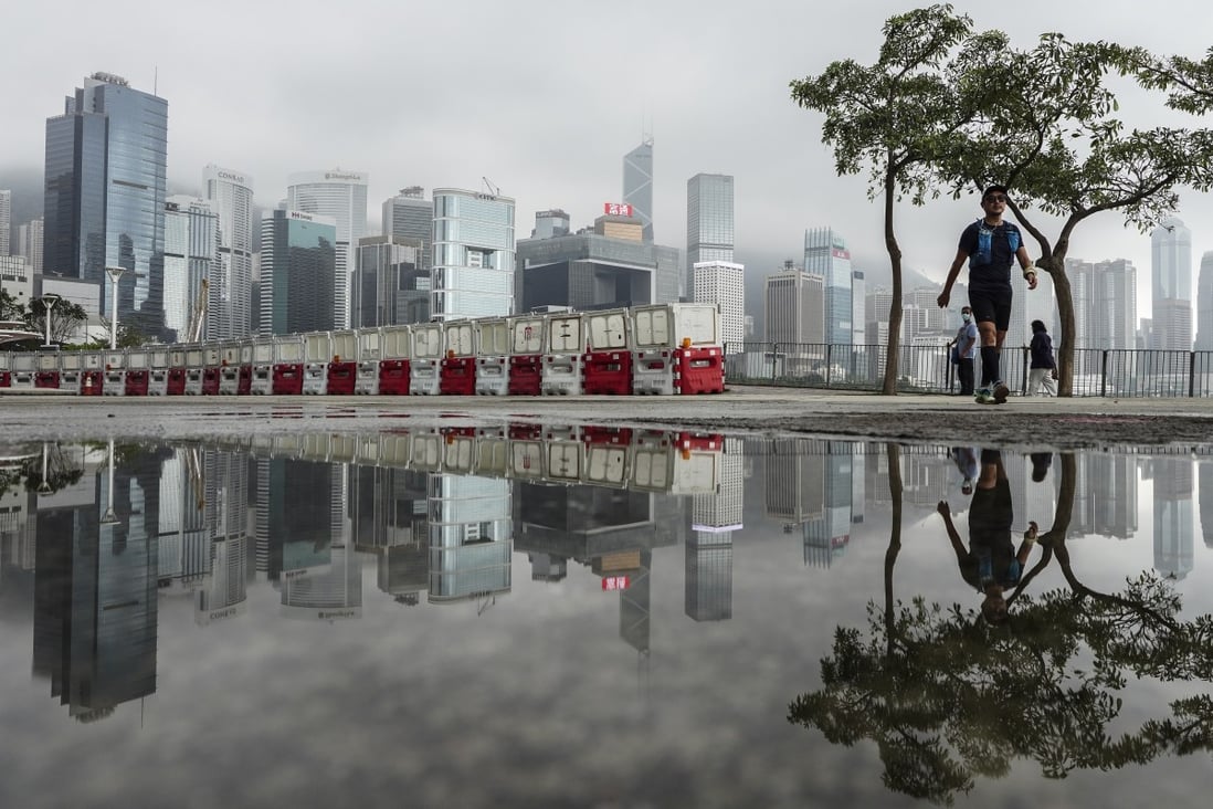 People walking cross the Wan Chai waterfront with the Central District area as background. Photo: SCMP / Robert Ng