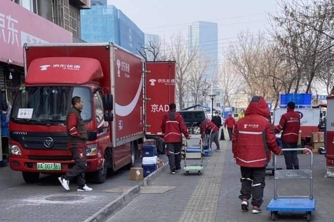Drivers move parcels from a delivery truck to their own vehicles at a JD Logistics distribution station in Chaoyang district, Beijing, on February 26, 2021. Photo: Minghe Hu