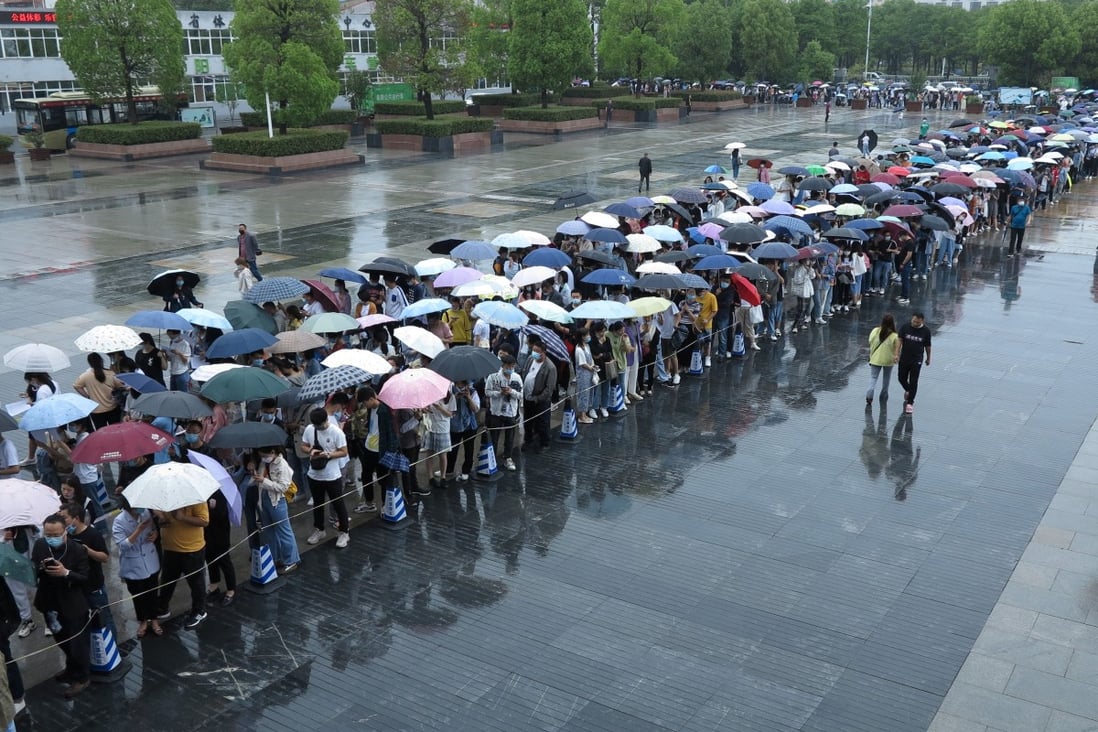 People line up in the rain to get vaccinated against the coronavirus in Fuyang, Anhui province, over the weekend. Photo: Reuters