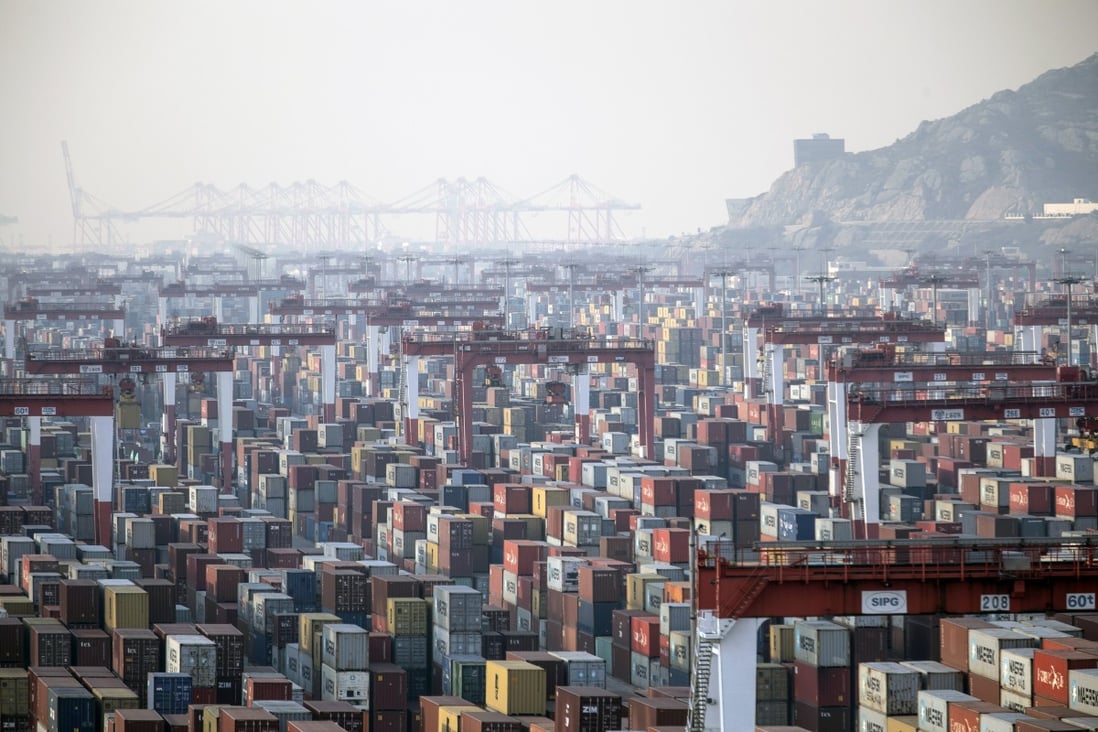 Shipping containers stand beneath gantry cranes at Yangshan port in Shanghai. World trade is gradually recovering but bringing the US-China trade war to a quick conclusion could make a marked difference. Photo: Bloomberg