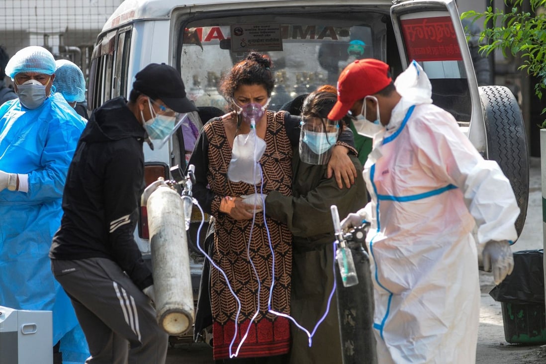 A Covid-19 patient breathes with the help of medical oxygen as she arrives at a hospital in Kathmandu, Nepal, on May 13. Photo: AFP