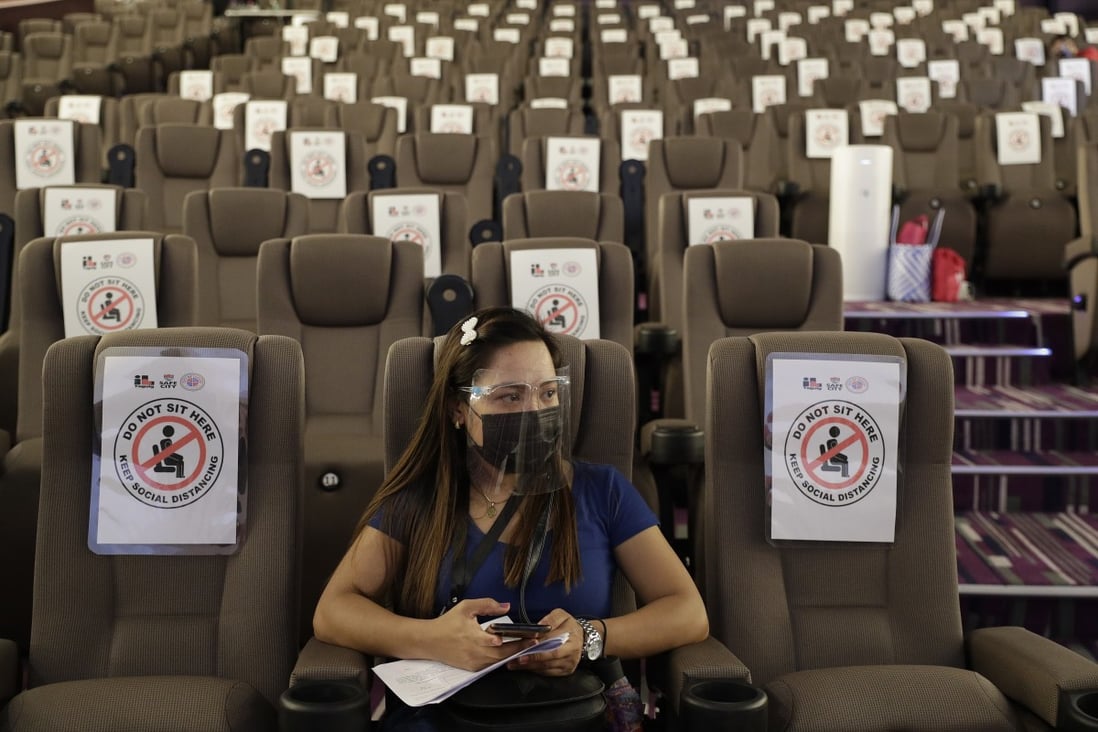 A woman waits in a cinema-turned vaccination hub at a mall in Taguig, Philippines. Photo: AP