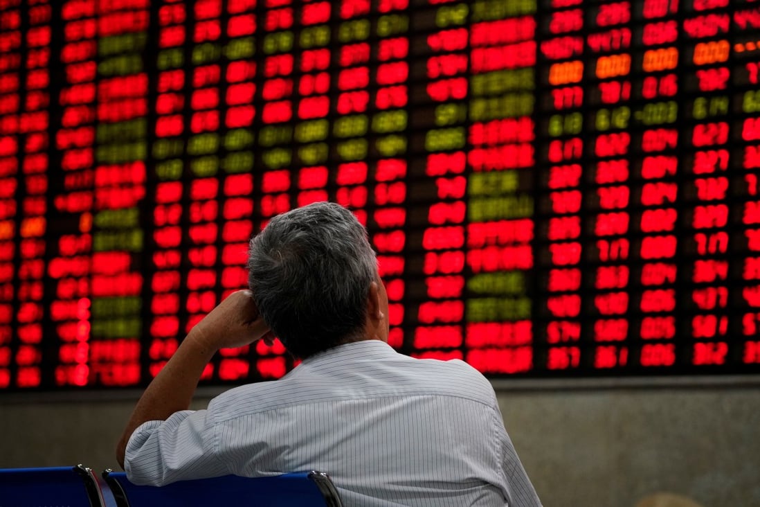 An investor looks at an electronic board showing stock information at a brokerage house in Shanghai. Photo: Reuters