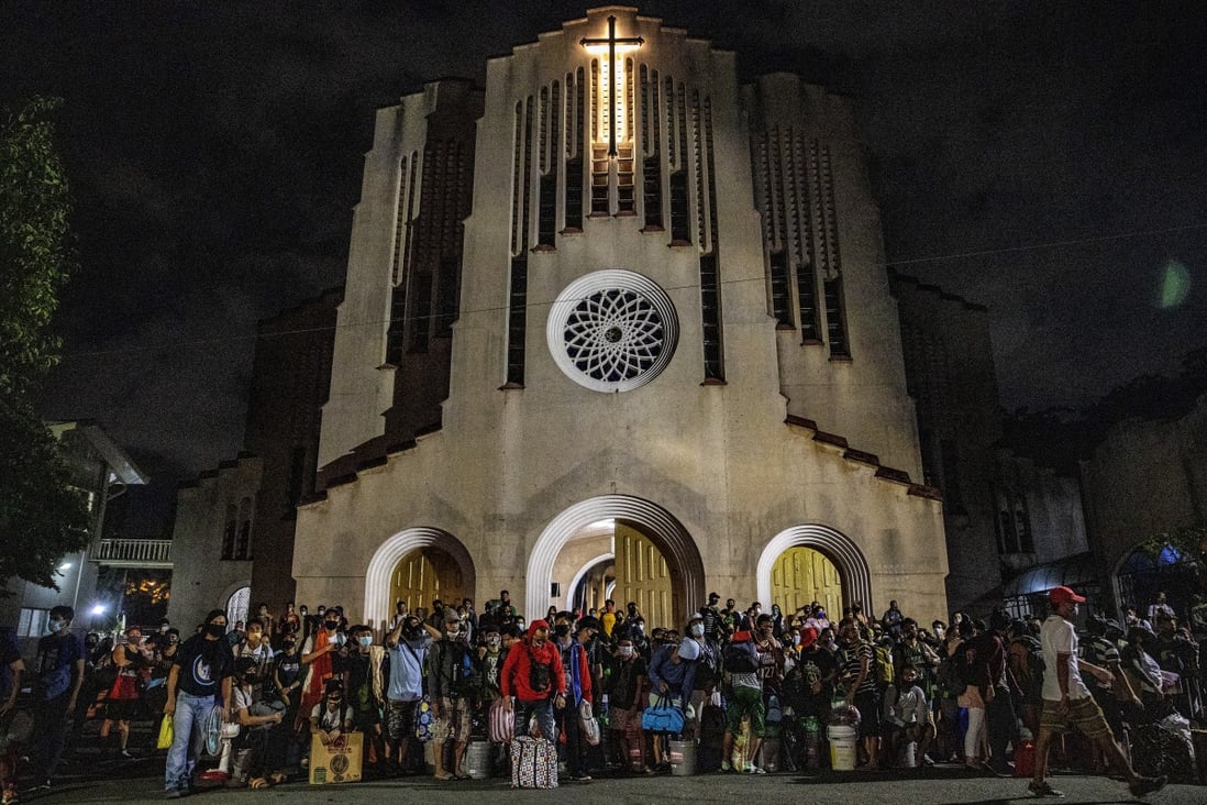Workers left jobless and stranded by the coronavirus pandemic queue outside a church as they wait for a free bus ride home to their province on May 29, 2020 in Metro Manila, the Philippines. Photo: Getty Images