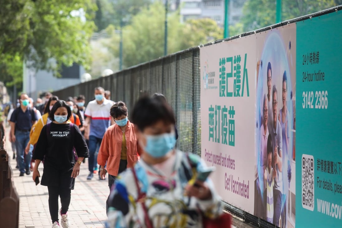 People walk past a banner encouraging Hongkongers to get vaccinated against Covid-19, in Causeway Bay on April 18. Photo: Xiaomei Chen