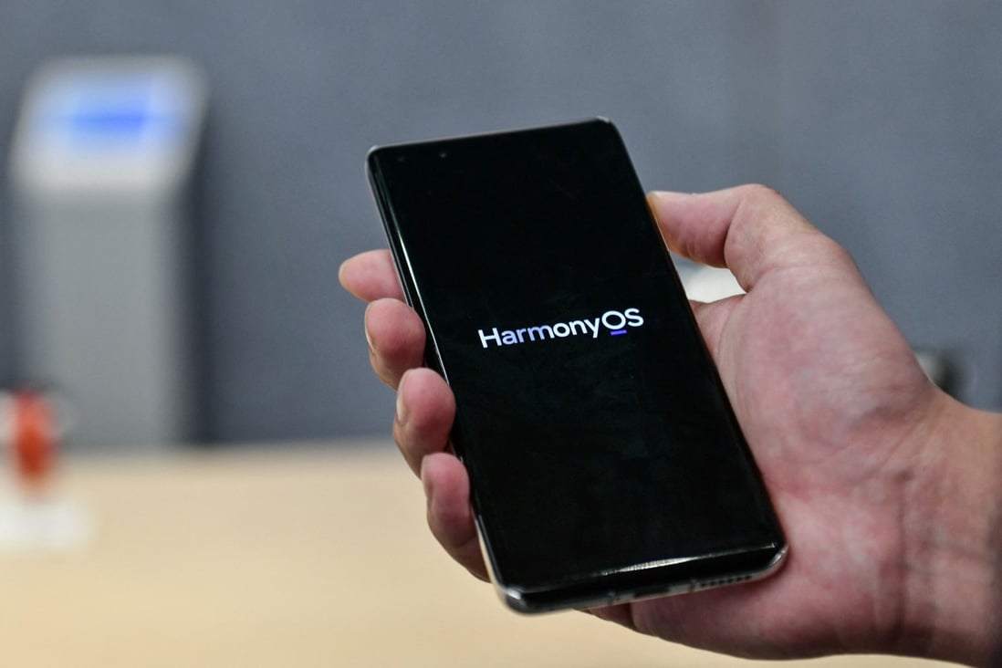 A staff member displaying a Huawei smartphone with the HarmonyOS operating system at the Huawei flagship store in Shenzhen, in China's southern Guangdong province, on May 31, 2021. HarmonyOS 2 is the company’s effort to bridge the gap between smartphones, tablets and myriad IoT devices has it tries to move away from Android. Photo: AFP