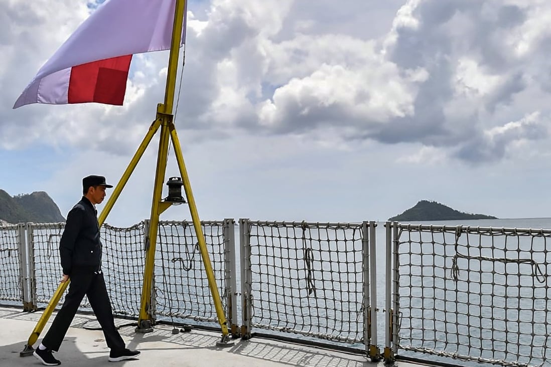 Indonesian President Joko Widodo walks past his country's flag on a navy ship during a visit to a military base in the Natuna islands, which border the South China Sea. Photo: Presidential Palace Handout via AFP