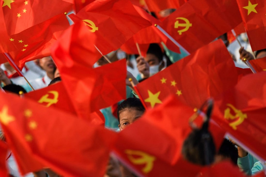 Students wave flags ahead of celebrations in Beijing on Thursday to mark 100 years of the Communist Party. Photo: AFP