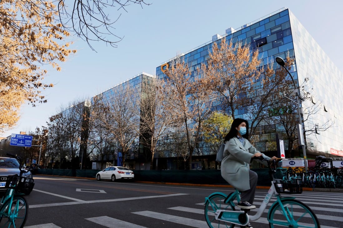 A woman rides a Didi shared bicycle past the headquarters of Didi Chuxing in Beijing, China November 20, 2020. Photo: Reuters