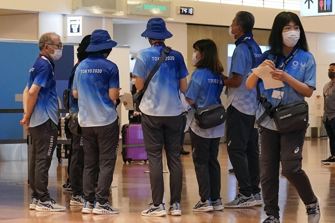 Tokyo 2020 volunteer staff clad in the blue-and-white uniforms. Photo: EPA-EFE