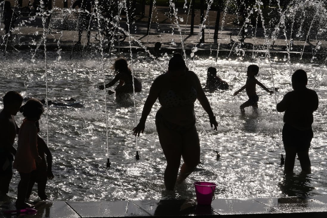 People cool off in a fountain in Madrid, Spain on Saturday. Chinese scientists have developed a fabric to help people stay cool as temperatures rise. Photo: AP