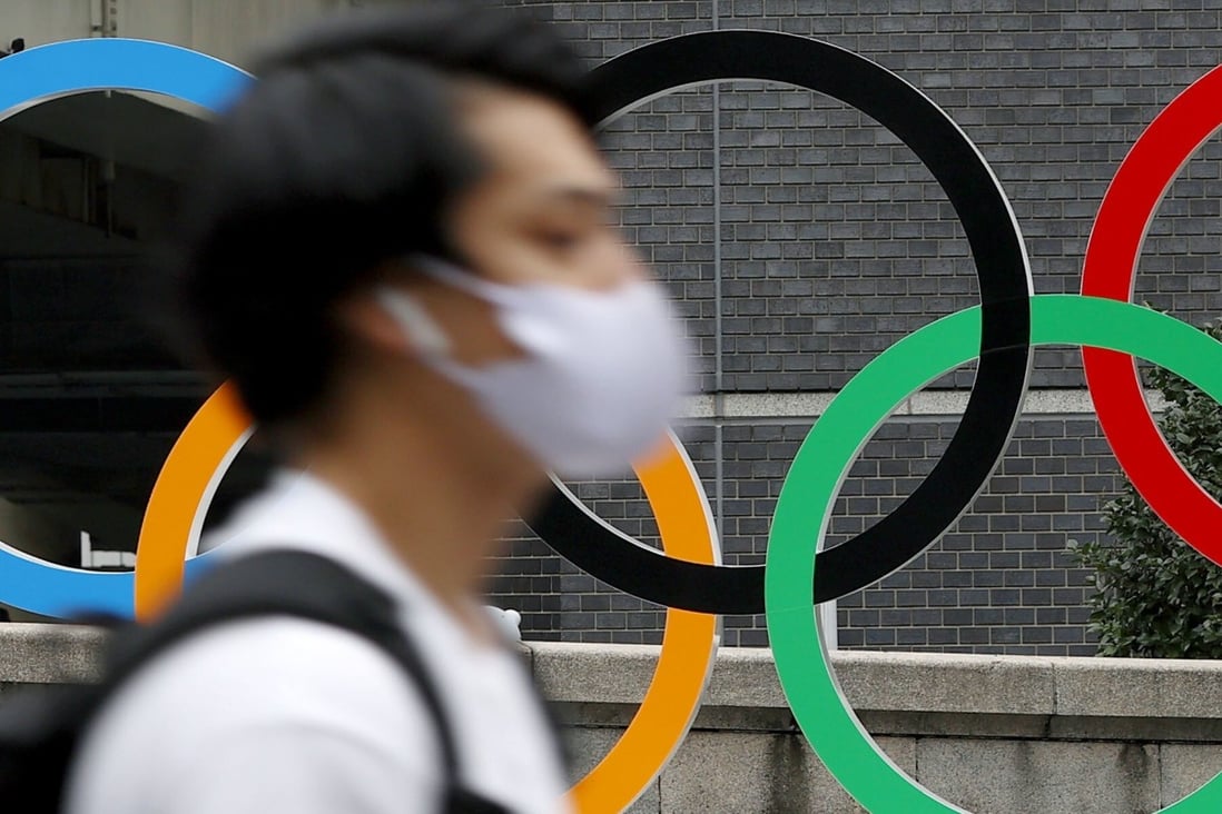 A pedestrian walks past the Olympic rings in Tokyo as the city counts down the final days to the Games. Photo: Kyodo