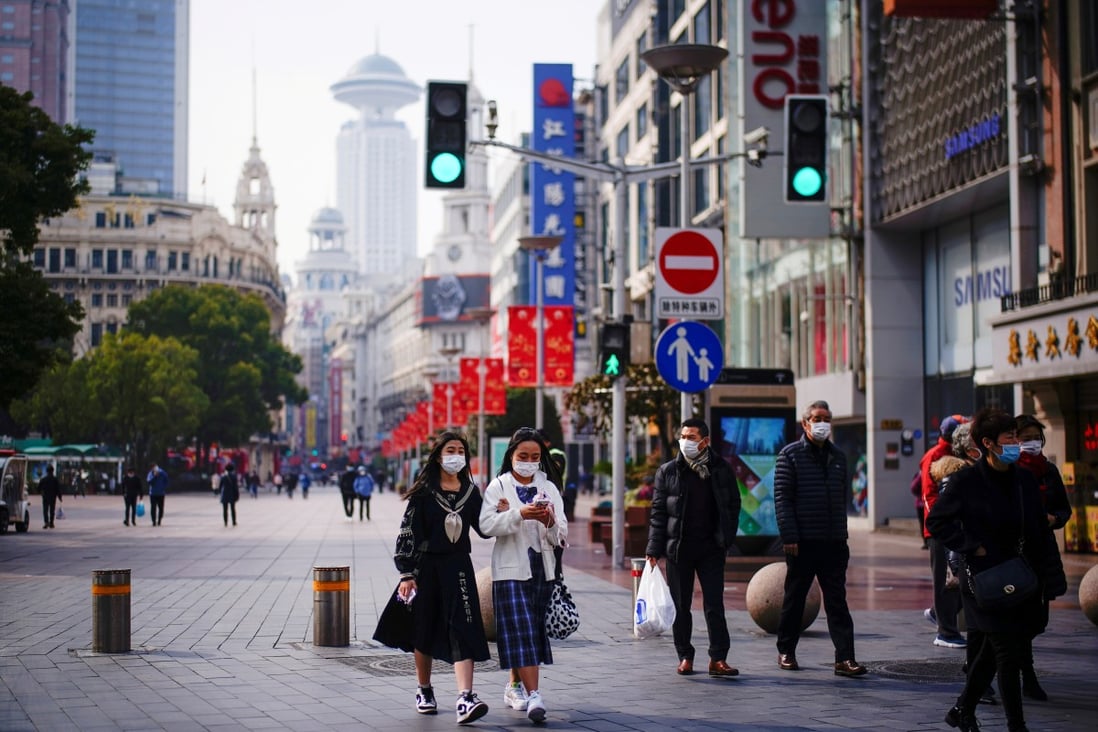 People wearing face masks walk at a main shopping area in Shanghai. Stocks closed higher, aided by China’s US$17 billion liquidity injection. Photo: Reuters