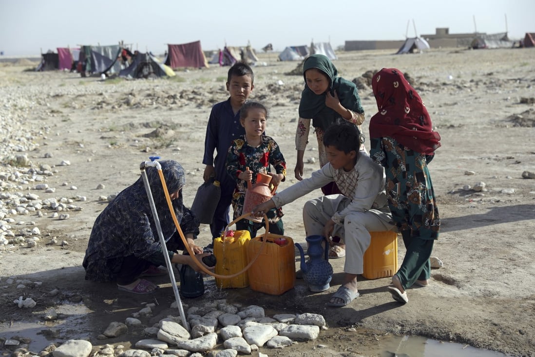 Internally displaced Afghans, who fled their home because of fighting between the Taliban and Afghan security personnel, fill water containers on the outskirts of Mazar-i-Sharif, northern Afghanistan, on July 8, 2021. Photo: AP Photo