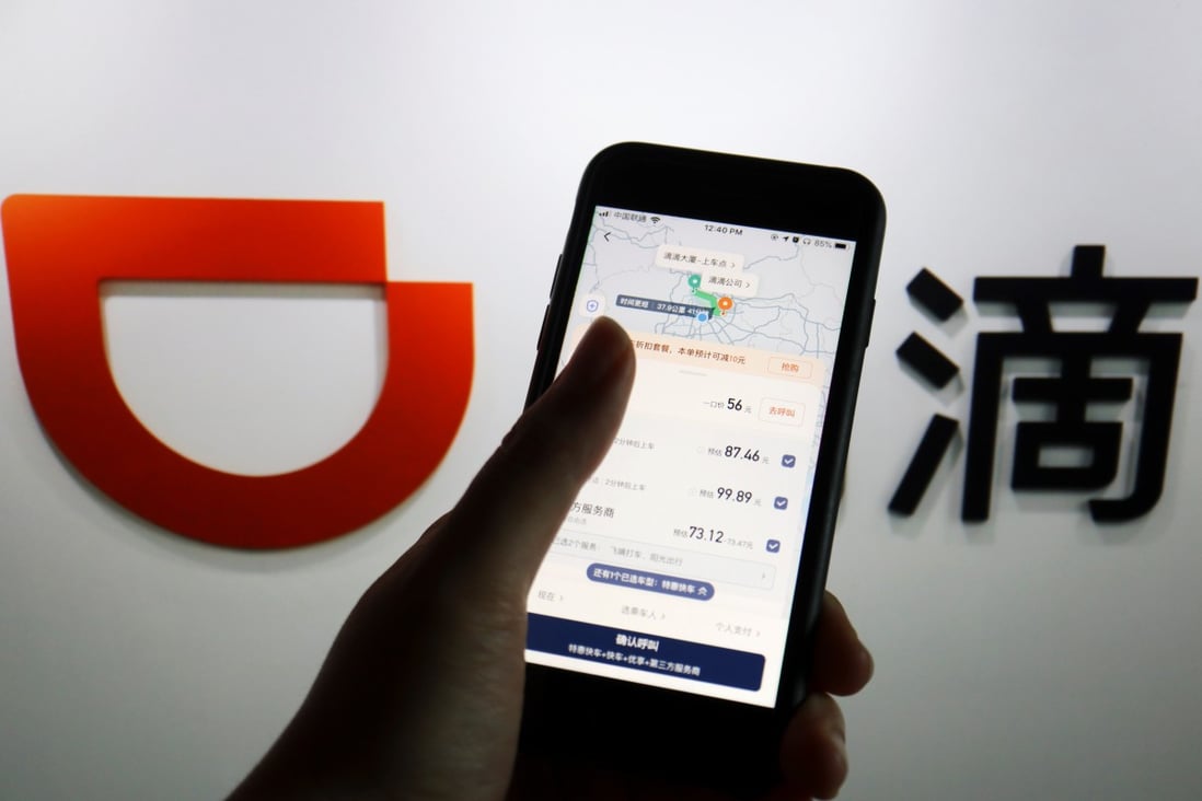 The app of Chinese ride-hailing giant Didi Chuxing is seen on a mobile phone in front of the company logo on July 1. Didi has become the subject of China’s first cybersecurity review, but the many different ministries involved suggest a broad scope. Photo: Reuters