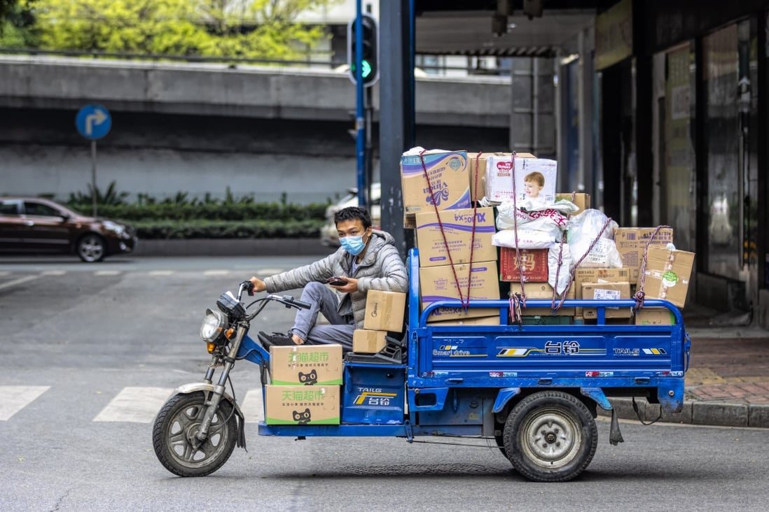 A man rides a delivery motorcycle on a street in a deserted workshop district and wears a mask in an attempt to protect himself from a coronavirus contagion in Guangzhou, Guangdong Province, China. Photo: EPA-EFE