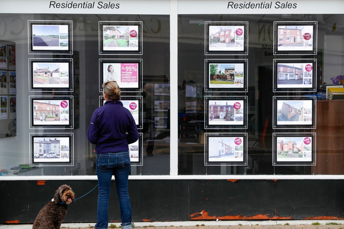 A pedestrian looks at residential sales displayed in the window of an estate agent in Loughborough, UK. Photo: Bloomberg