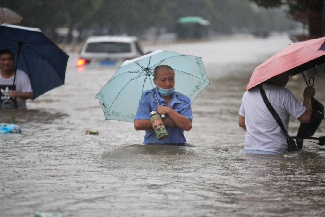 Residents wade through floodwaters in Zhengzhou on Tuesday. Photo: Reuters