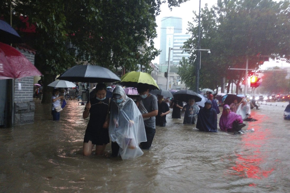 City residents wade through heavy flood waters. Photo: AP