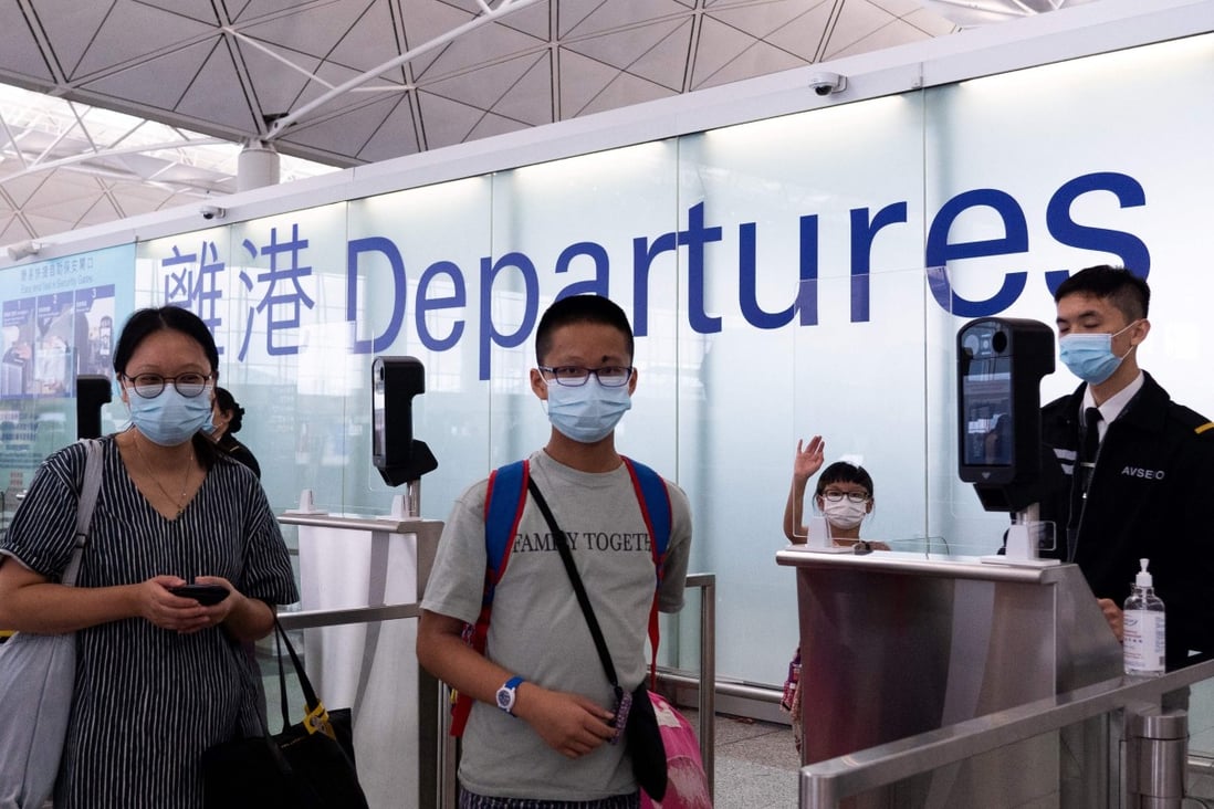 A family pose for a photo before entering the departures hall for their flight to Britain at Hong Kong’s International Airport on July 18. Photo: AFP