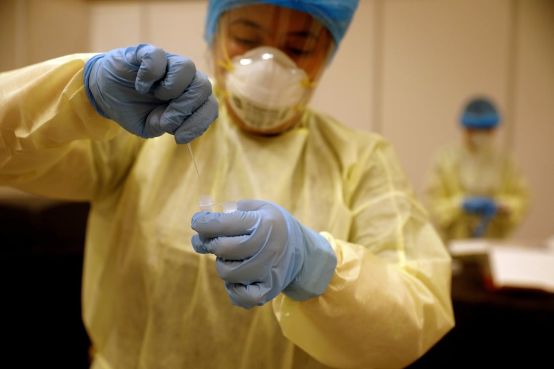A health care worker takes a nose swab for a coronavirus test in Singapore, which has seen a recent surge in cases. Photo: Reuters