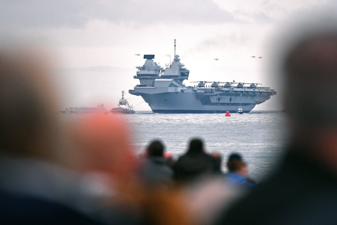 People line the shore to watch as tug boats manoeuvre the 65,000-tonne British aircraft carrier HMS Queen Elizabeth into Portsmouth Harbour in 2017. Photo: AFP