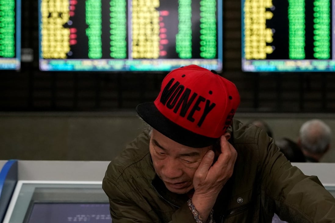 An investor looks at computer screens showing stock information at a brokerage in Shanghai. Photo: Reuters